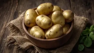 Korba s celými zlatavými bramborama na lněném plátně.