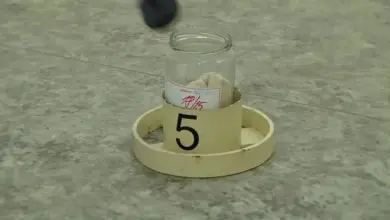 Skleněná nádobka na sběr důkazů s bílým předmětem uvnitř.