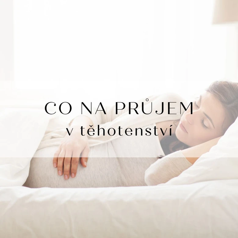 Těhotná žena spí v posteli a drží si břicho.