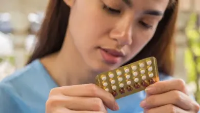 Žena drží v rukou balení hormonální antikoncepce.