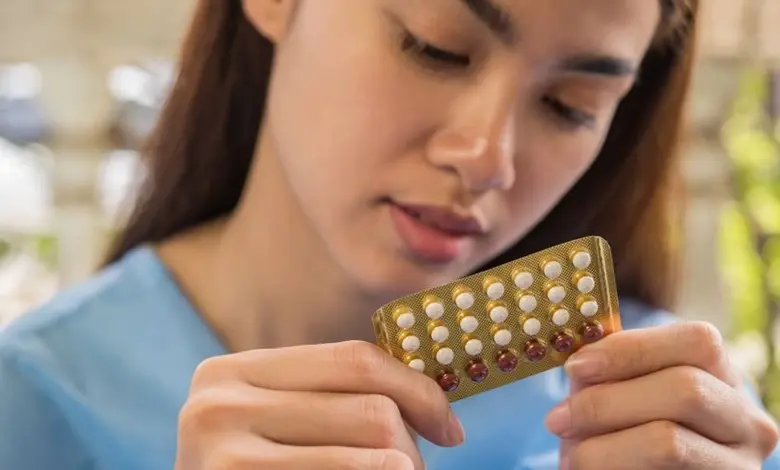 Žena drží v rukou balení hormonální antikoncepce.