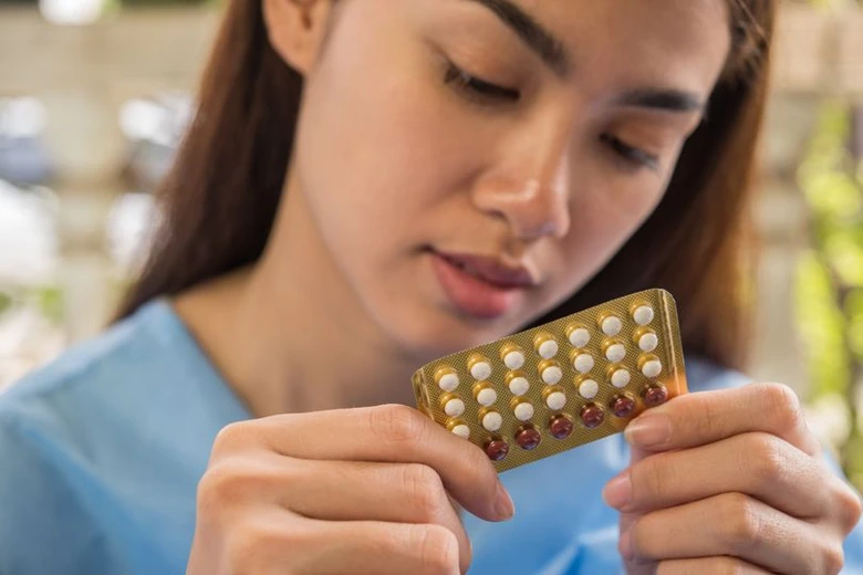 Žena drží v rukou balení hormonální antikoncepce.