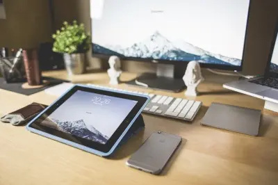Stůl s elektronickými zařízeními jako tablet a mobilní telefon.