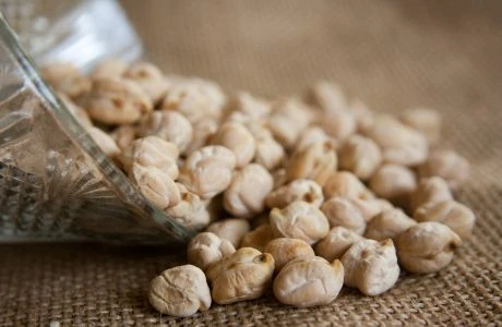 Dried chickpeas spilling from glass bowl