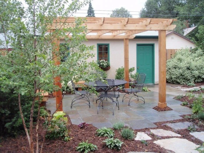 Dřevěná pergola na zahradě s venkovním nábytkem