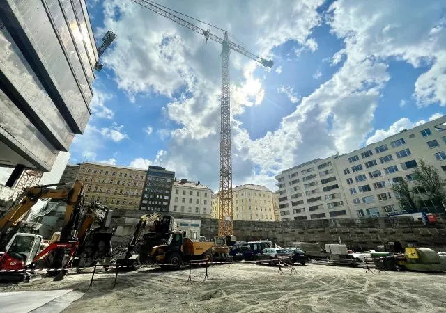 Staveniště s žebřicovou věží a těžkou technikou v centru Prahy.