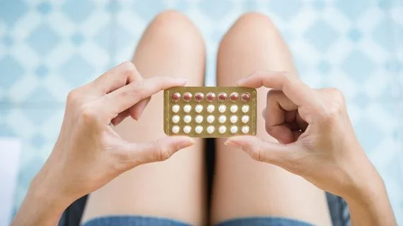 Žena drží v rukou balení hormonální antikoncepce.