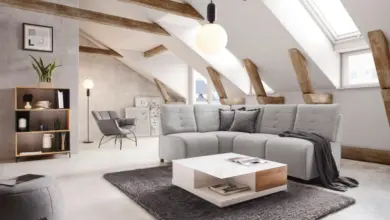 Moderní obývací pokoj s šedou pohovkou v podkrovím.